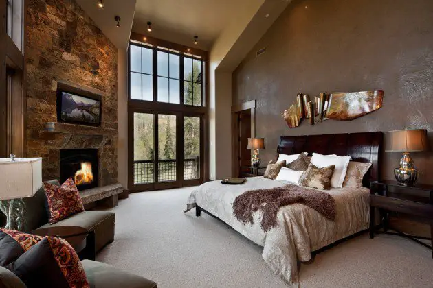 Warm colors and rustic fireplace give this bedroom a cozy feel (architectureartdesigns.com)