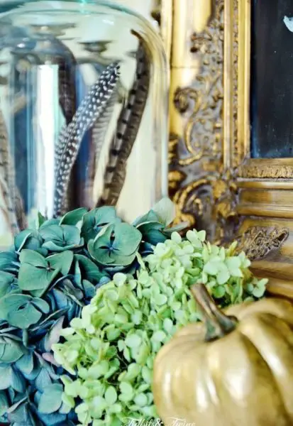 Blue and green hydrangea blooms and feathers accent this fall display (hometalk.com)