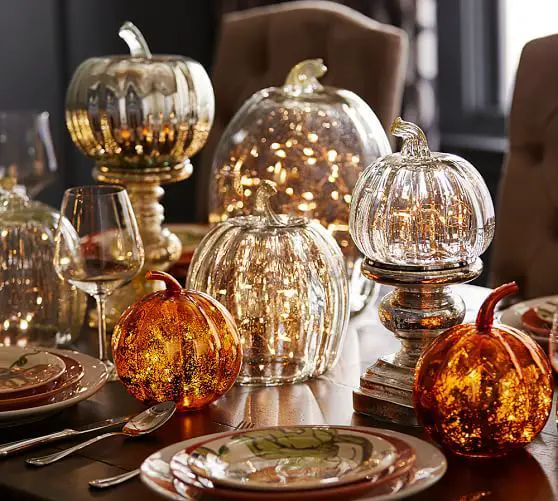 Lighted glass pumpkins (available at Pottery Barn) illuminate a table 