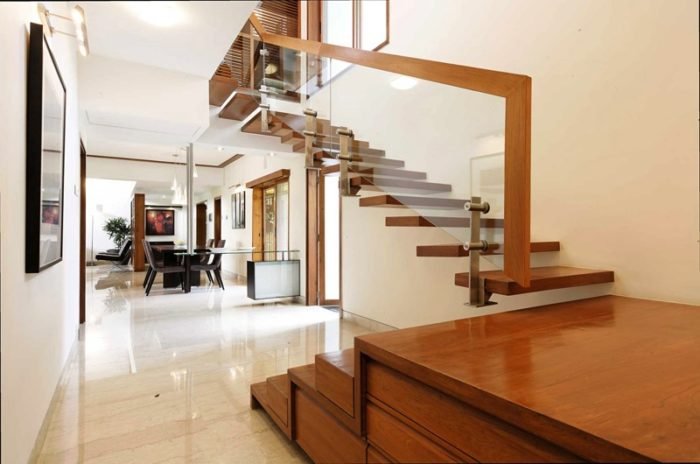 Warm wood tones set off this glass and wood staircase (homedesigning.com)