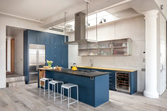Blue cabinetry accents the kitchen (trendir.com)