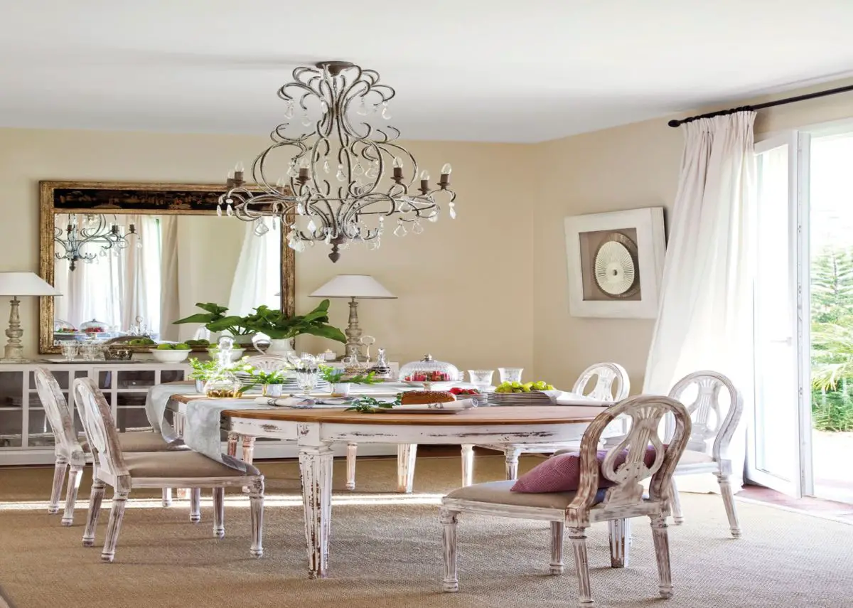 Dining room with pickled table and chairs and chandelier. To the wind.